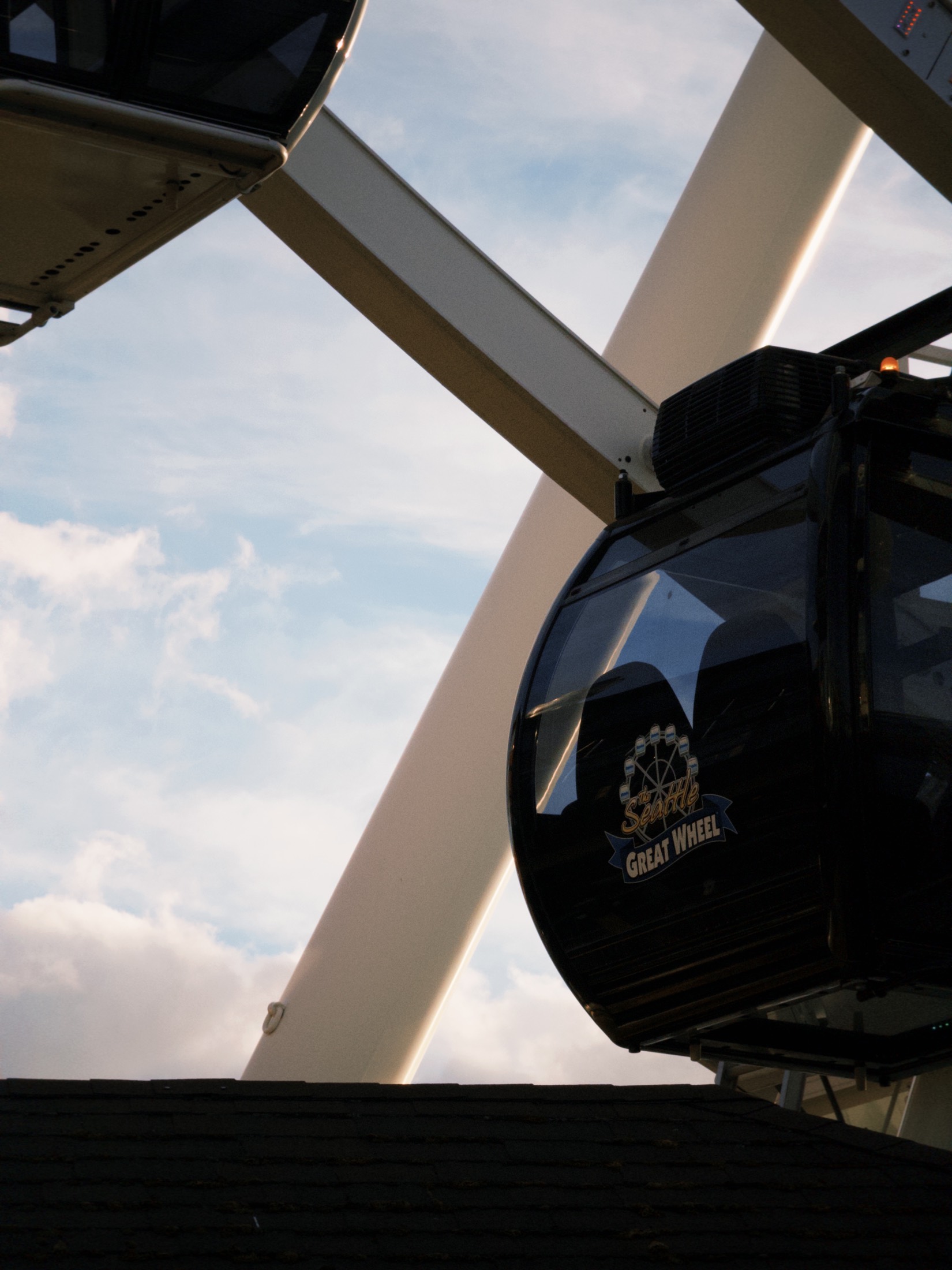 A close view of a Seattle Great Wheel gondola framed by white support beams.